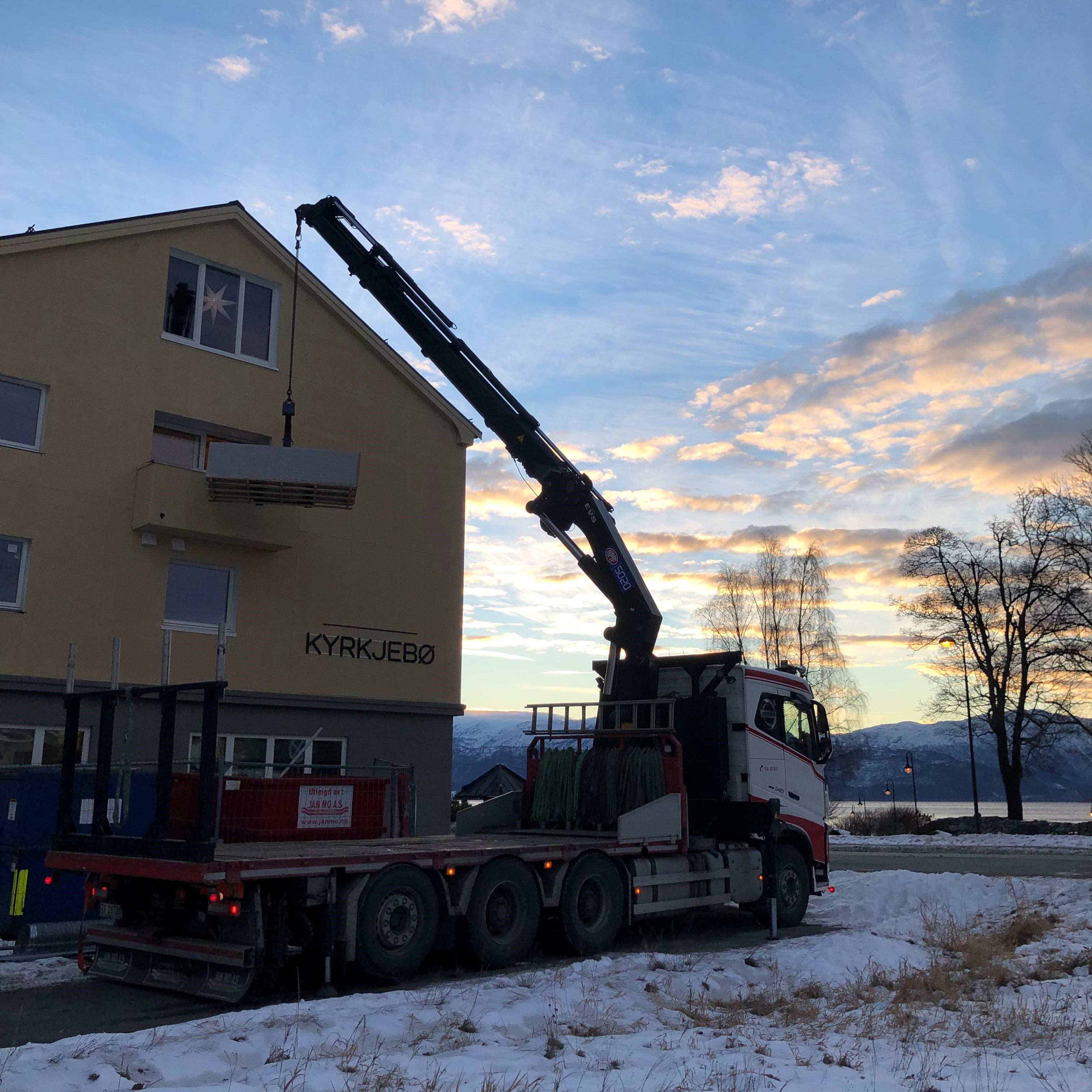 Grue 5020K-RCS soulevant des matériaux par la fenêtre d'une maison