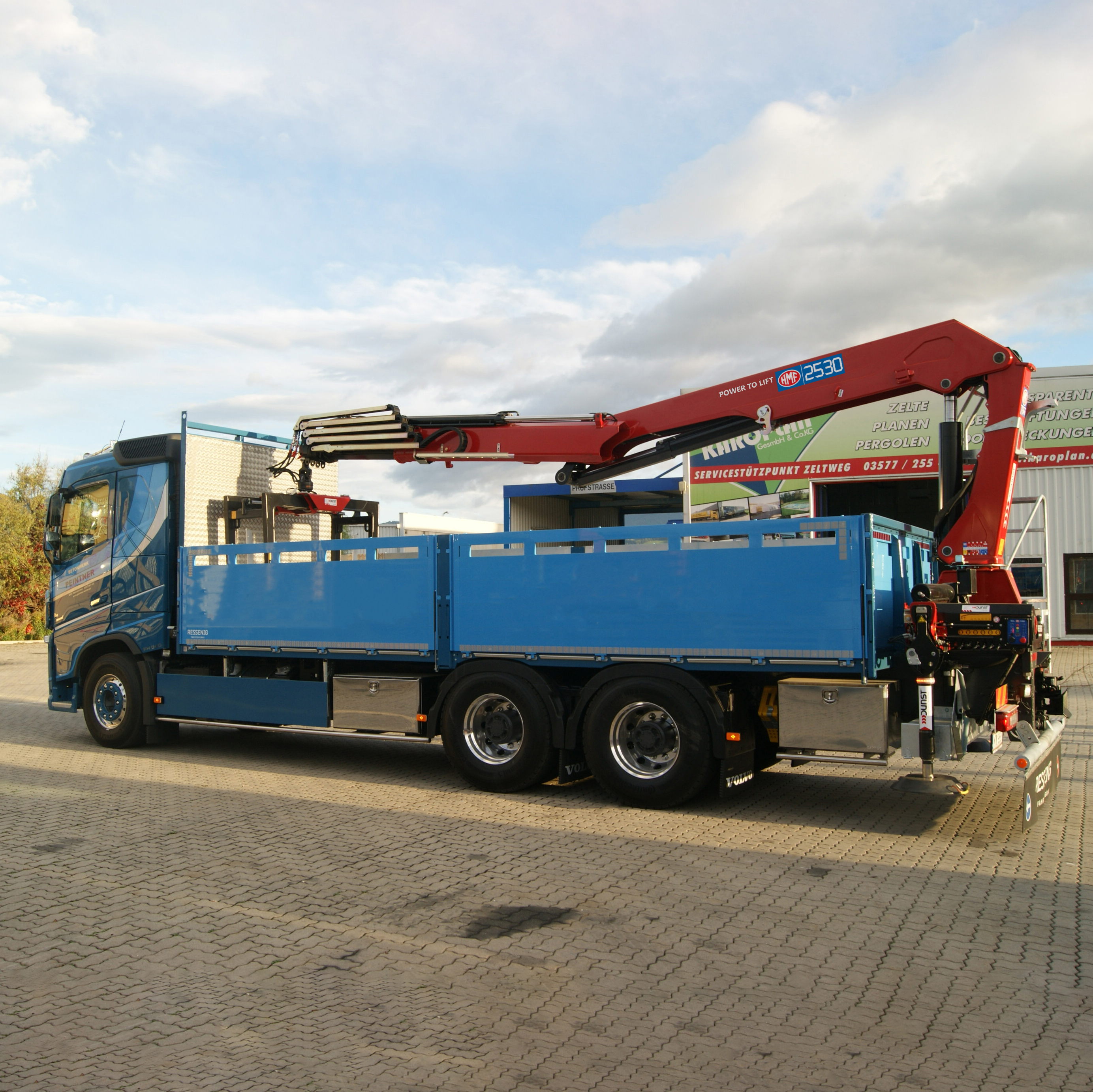 25 tonne meter long boom crane stowed over truck body with grab