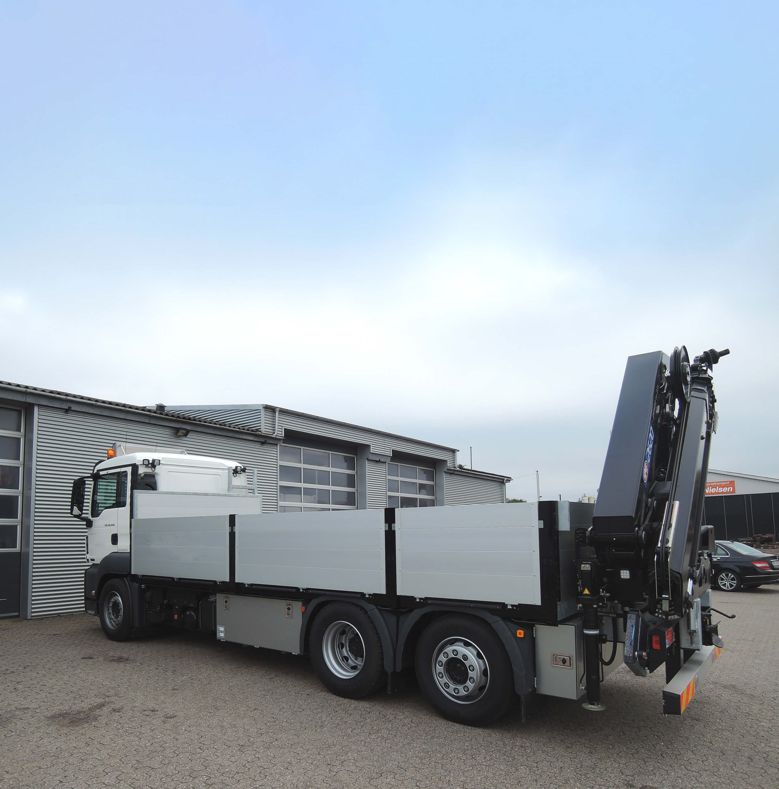 Lastbil med fastlad og kran